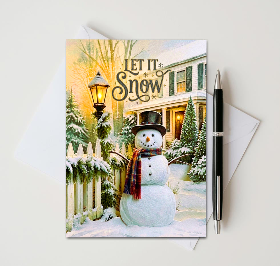 Let It Snow card with plaid-scarf snowman beside a glowing lantern and snow-covered fence
